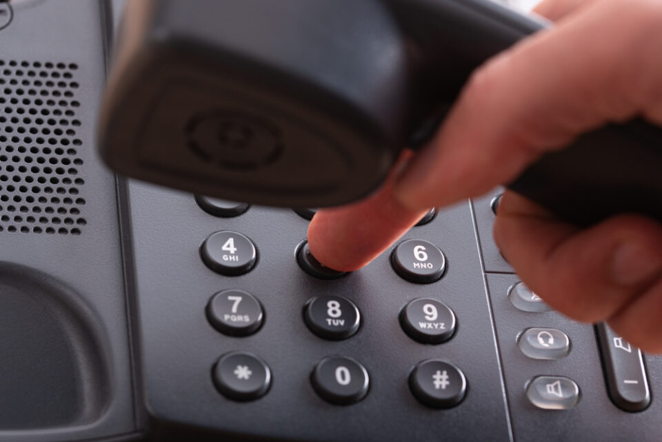 Close up van vinger die telefoonnummer kiest