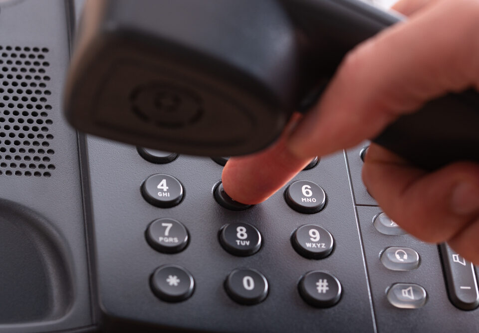 Close up van vinger die telefoonnummer kiest