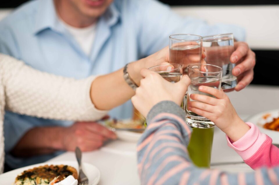 Familie proost met waterglazen