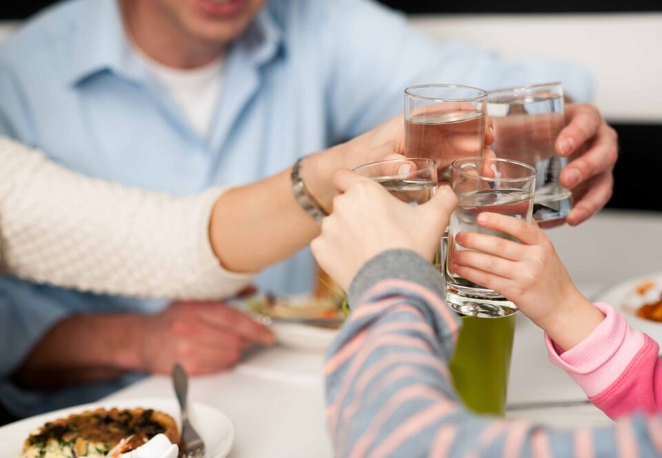 Familie proost met waterglazen